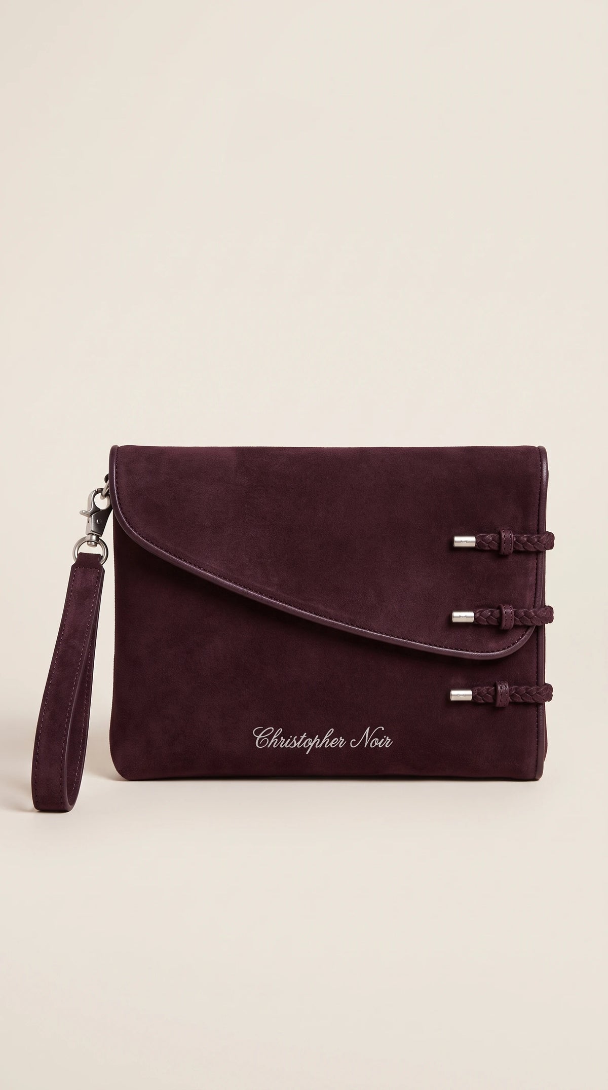 The Noir Dunster aubergine suede-finish leather clutch, front view with three braided leather loop fastenings and detachable wrist strap