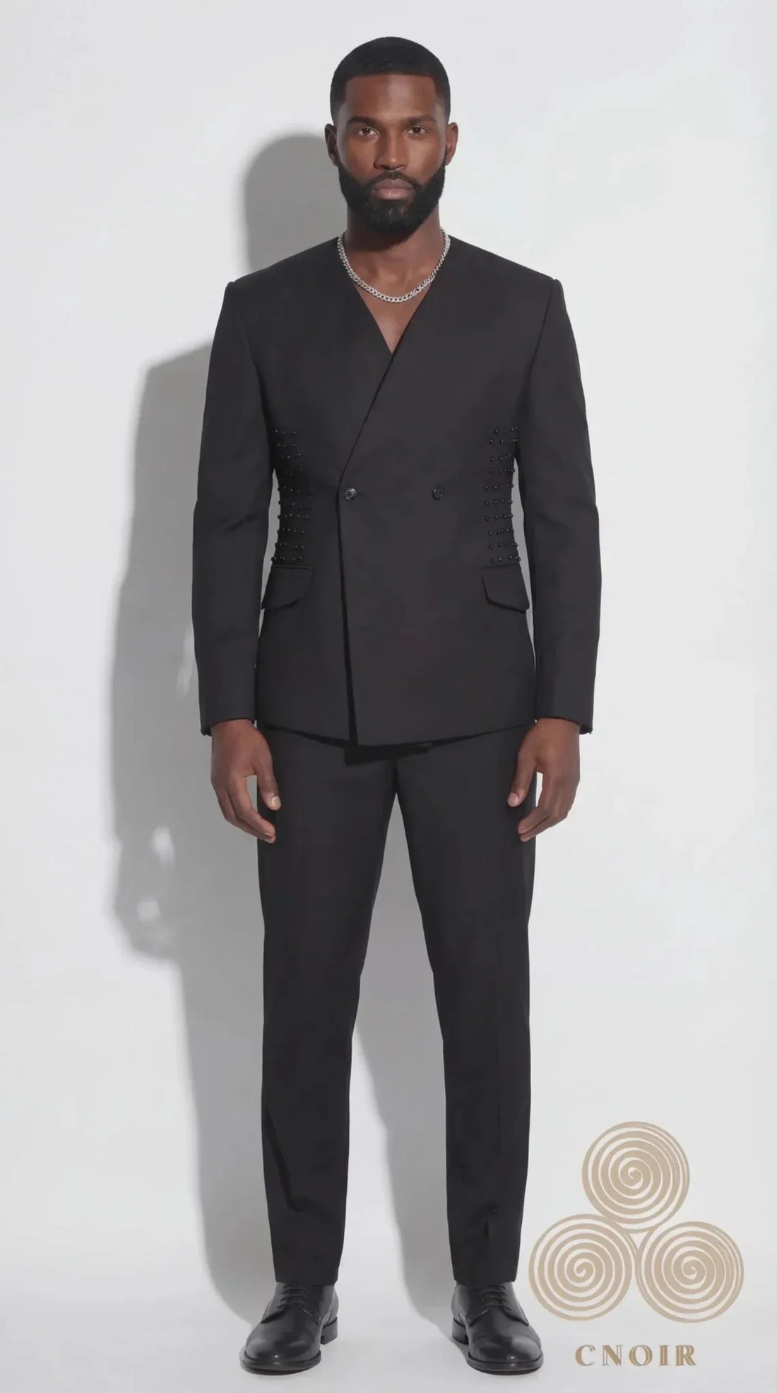 The Noir Eclipse Suit — collarless deep V-neck black jacket with black stud detailing