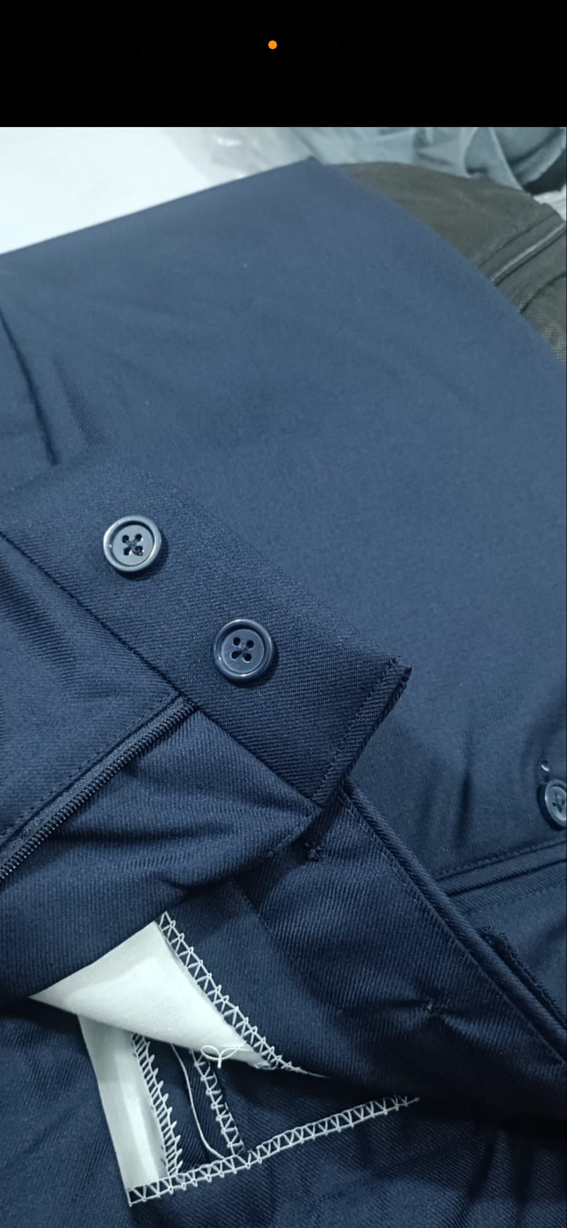 Close-up of a blue jacket with buttons and white lining.