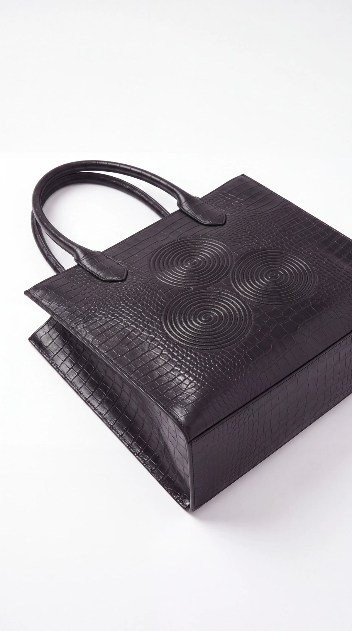 Christopher Noir Ashbourne black croc-embossed logo tote, top-down view of embossed spiral signature