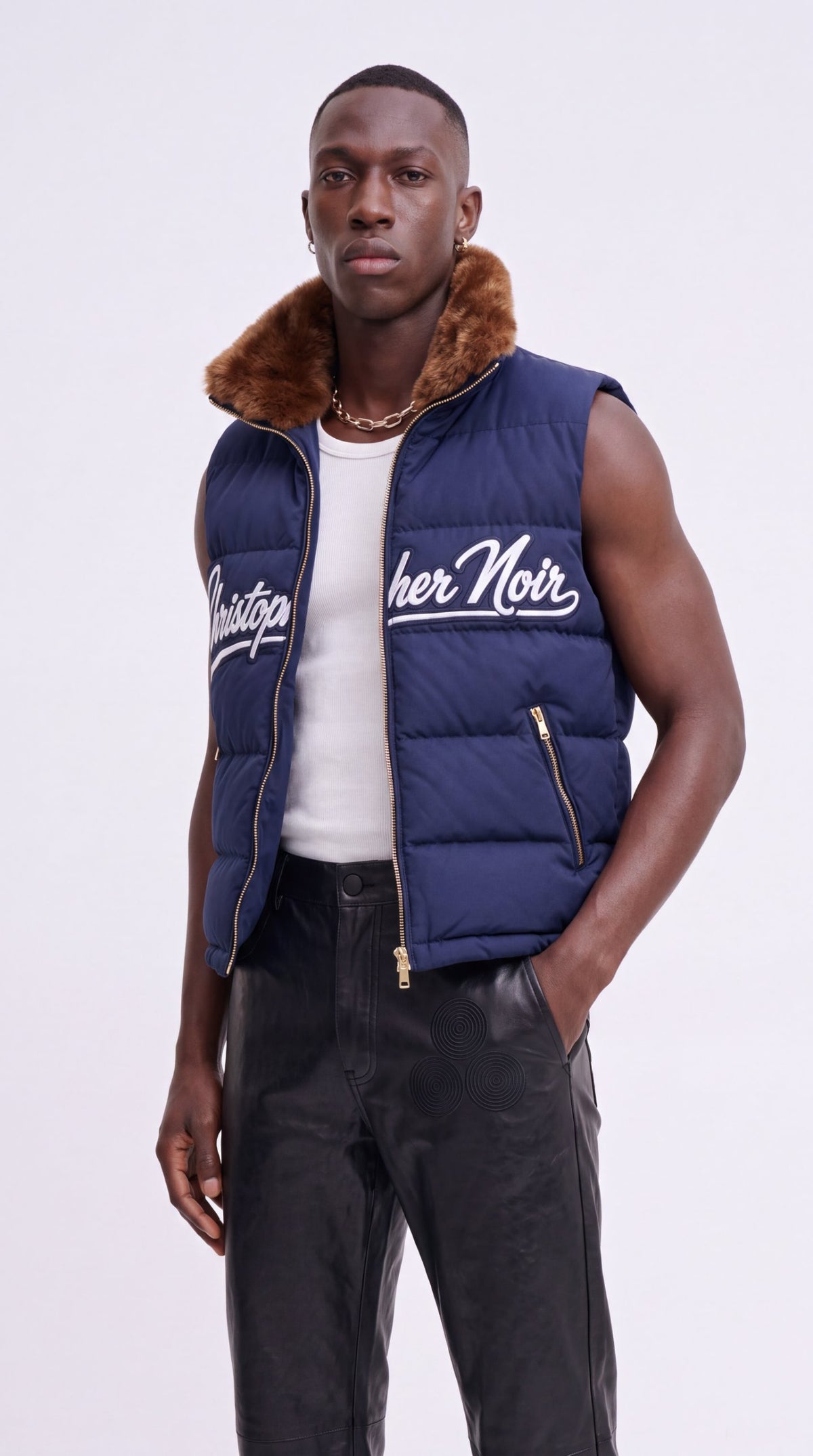 The Noir Bute navy faux-fur collar signature puffer gilet worn open, by Christopher Noir