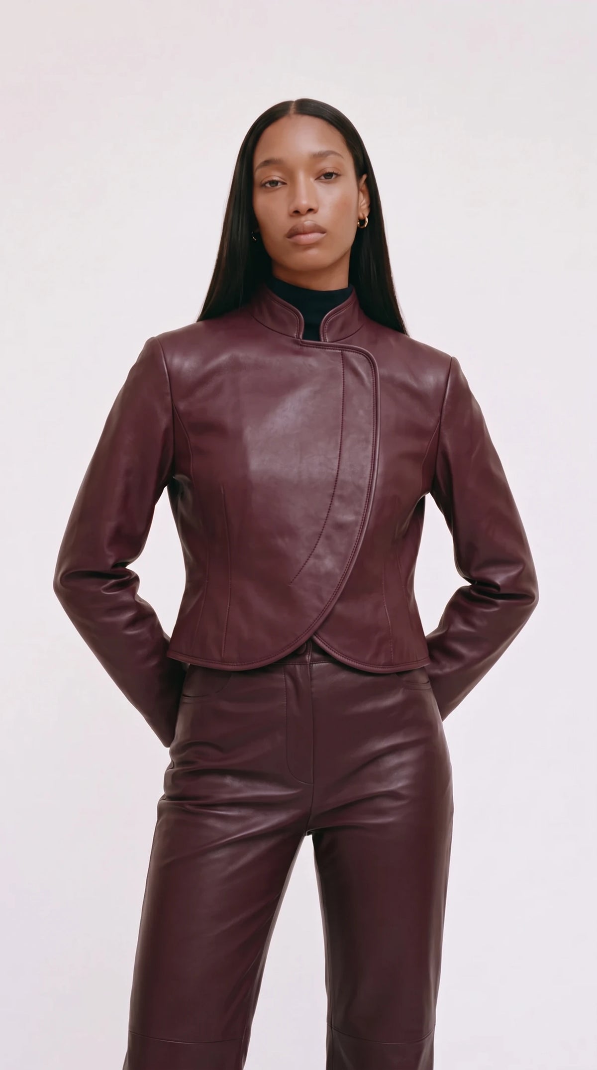 The Noir Copinsay cropped oxblood leather jacket with stand collar and piped crescent wrap front