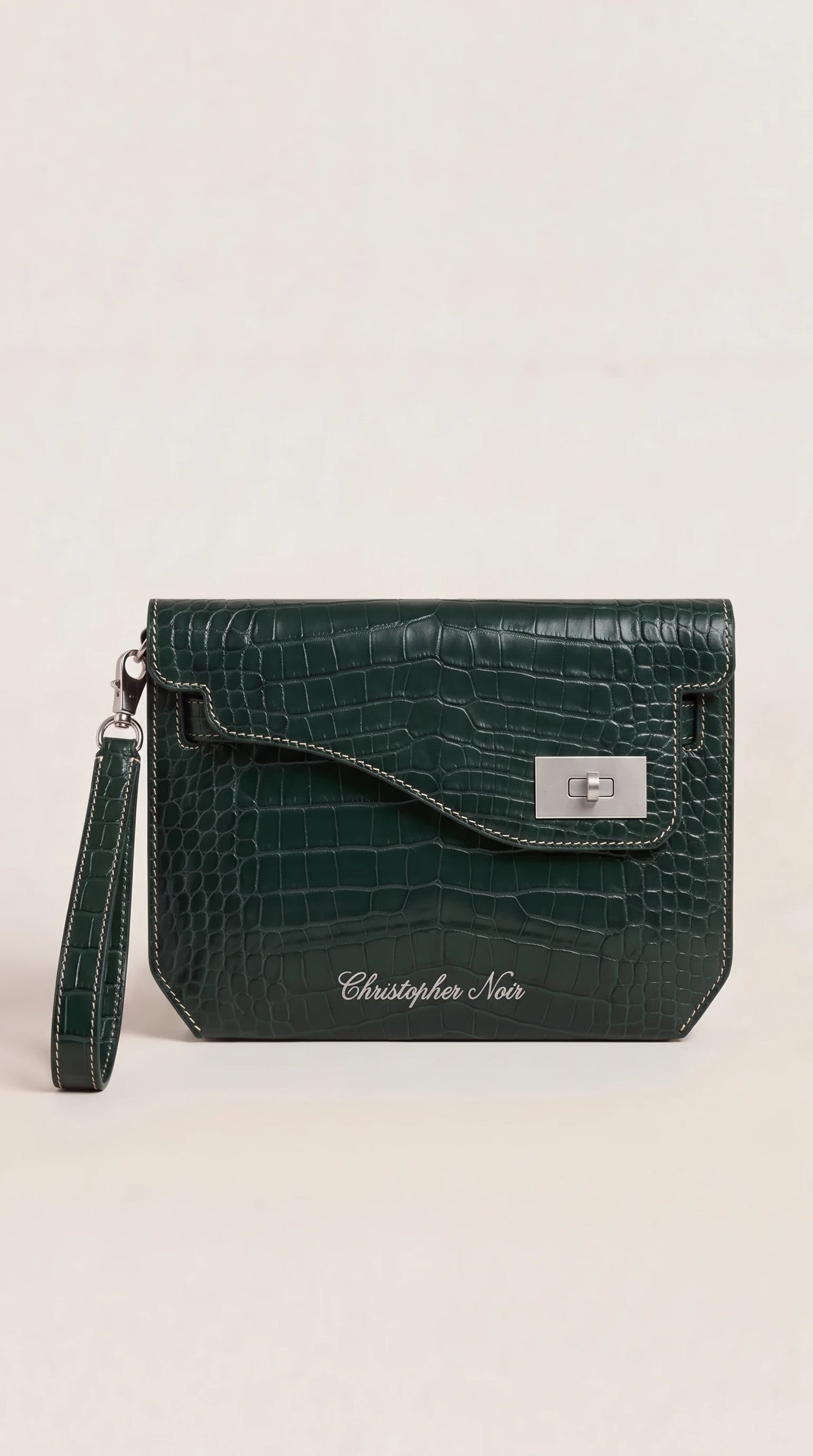 The Noir Kelmscott forest green croc-effect leather clutch, front view with contrast cream saddle stitching and silver-tone turn-lock