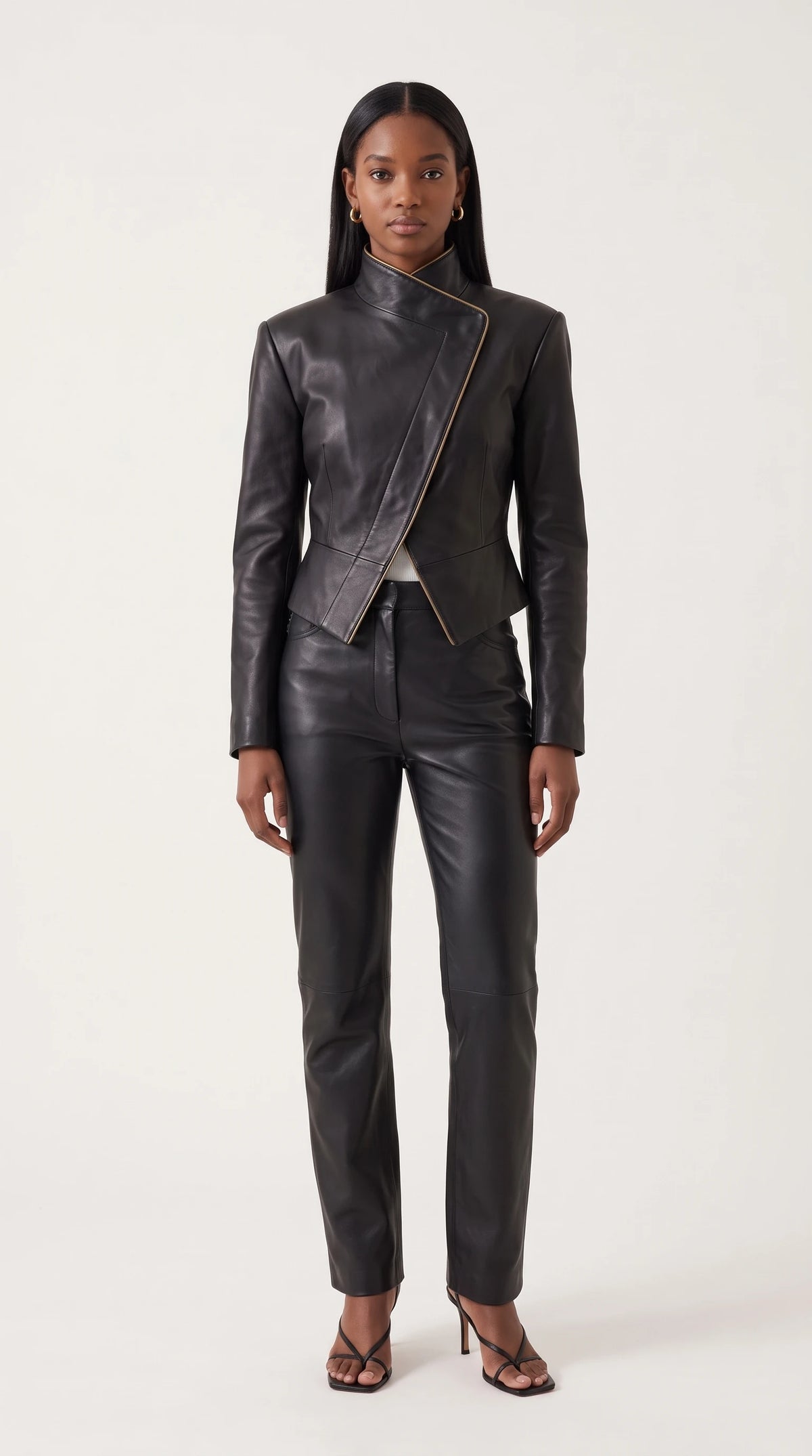 The Noir Mousa black leather wrap jacket with high stand collar and gold-tone piped asymmetric front