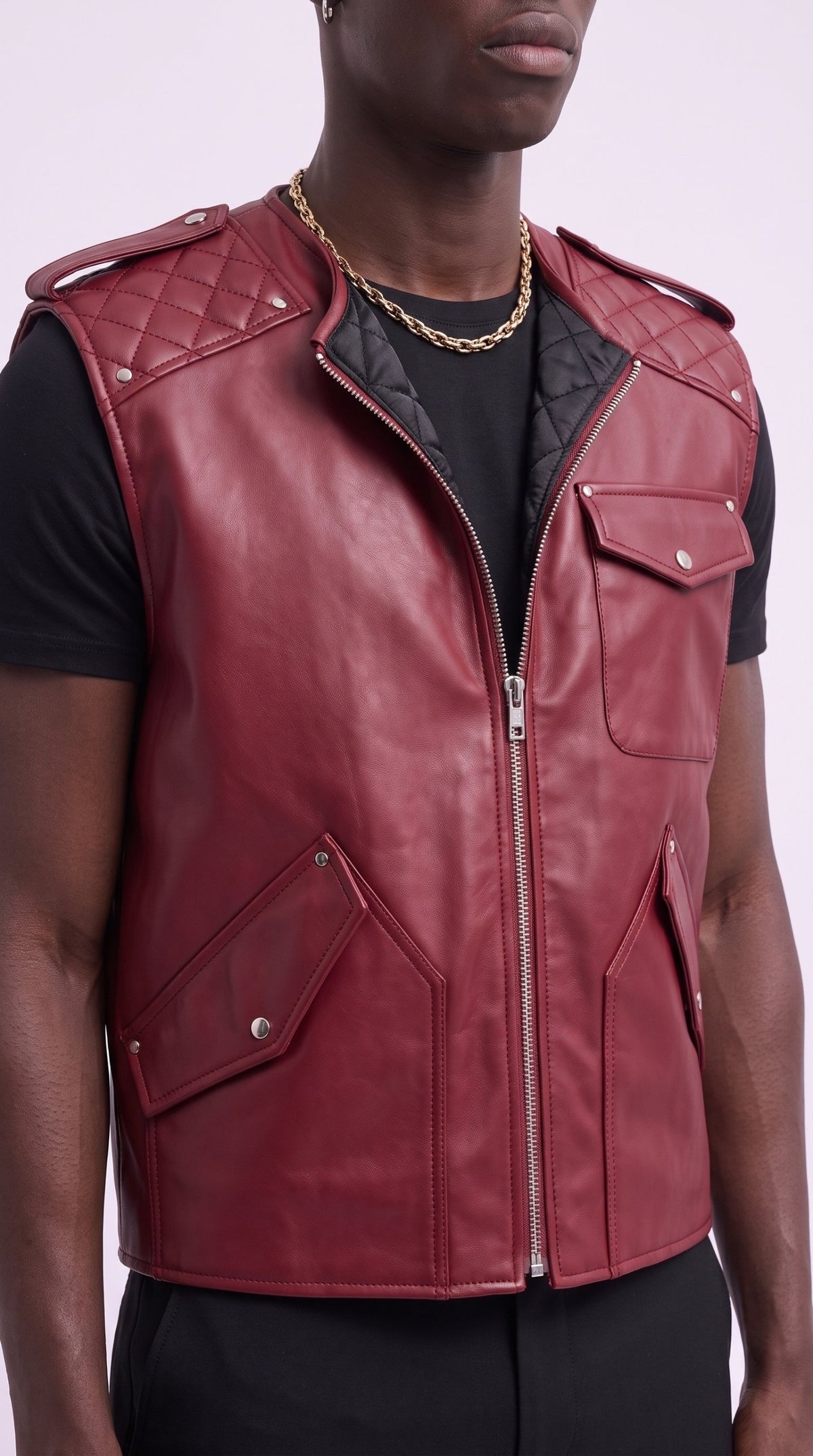 Close-up of the crimson leather gilet's quilted shoulder, silver-tone zip and studded pockets