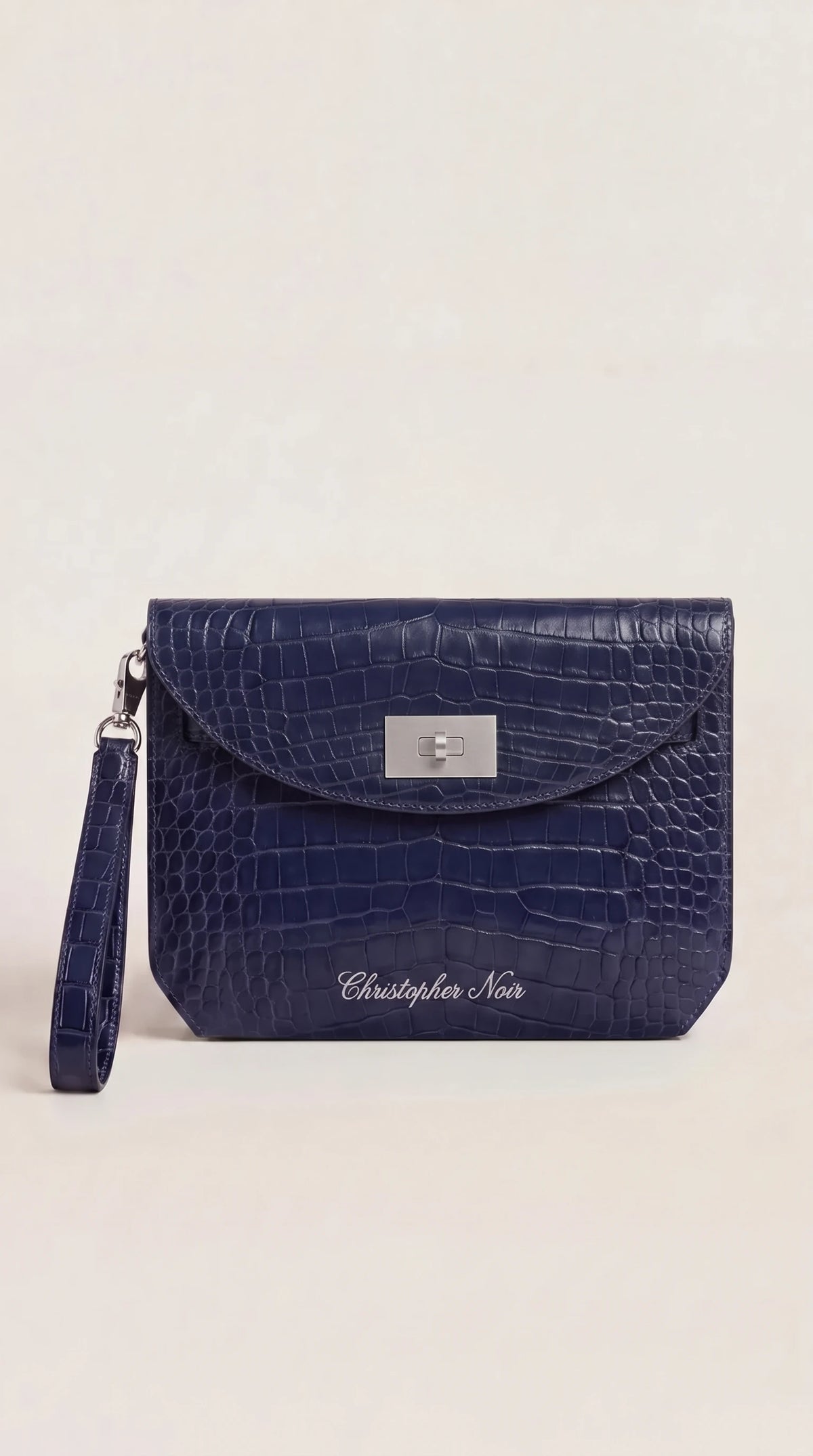 The Noir Wentworth navy croc-effect leather wristlet clutch, front view with silver-tone turn-lock and detachable wrist strap