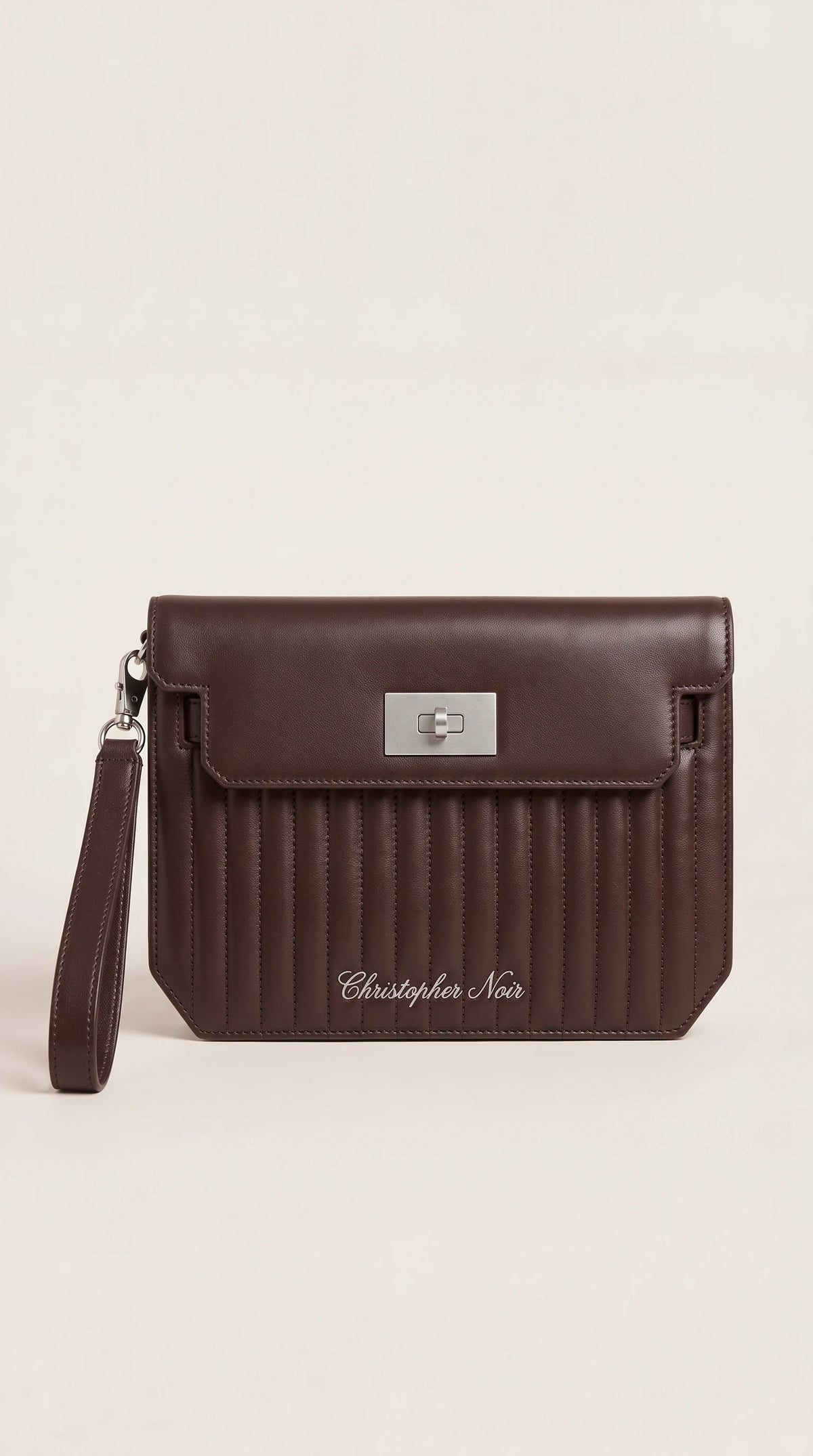 The Noir Winslow chocolate brown channel-quilted leather wristlet clutch, front view with silver-tone turn-lock and detachable wrist strap