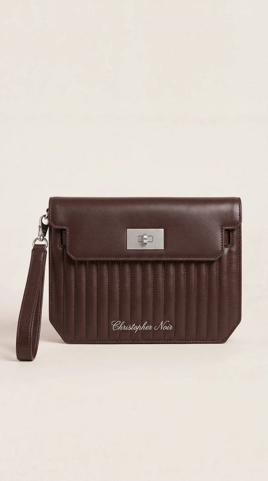 The Noir Winslow chocolate brown channel-quilted leather wristlet clutch, front view with silver-tone turn-lock and detachable wrist strap
